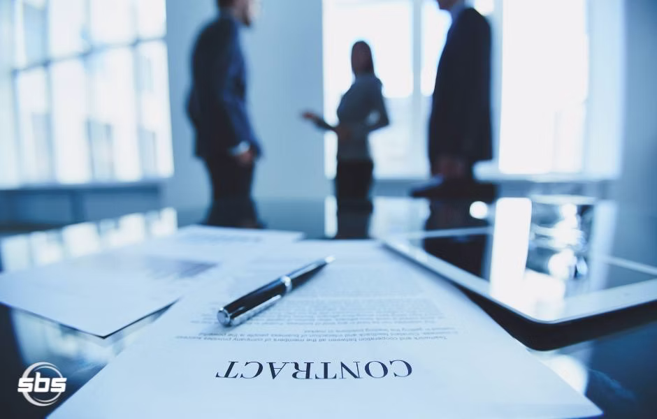 A contract with a pen and people discussing it.